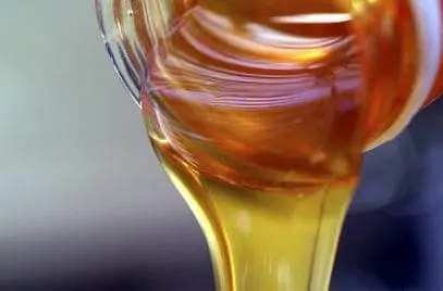 Pouring honey from jar