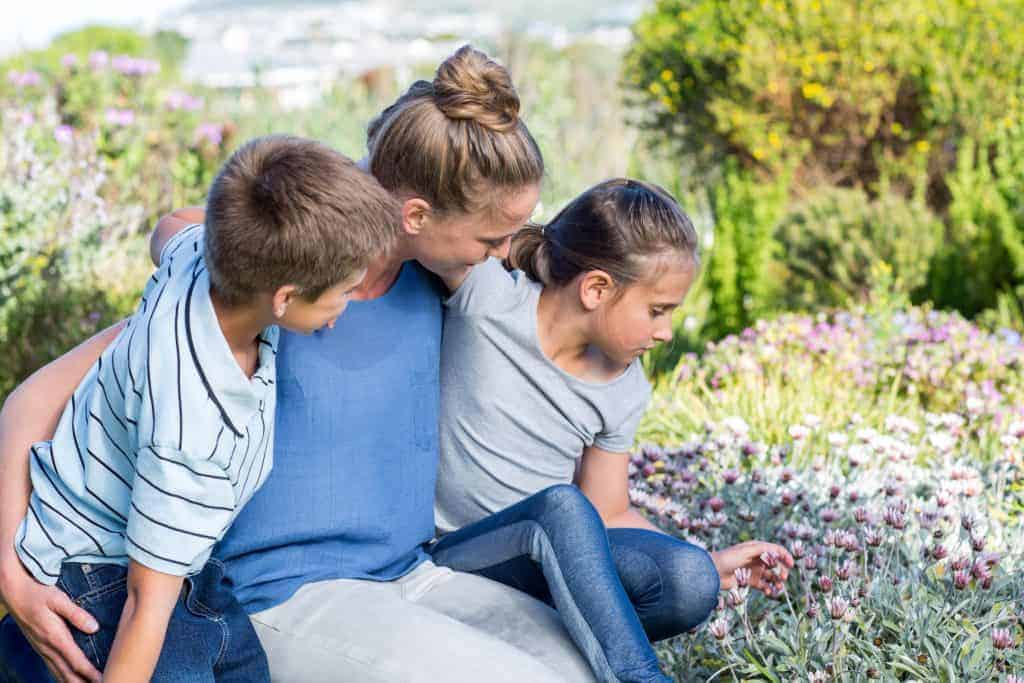 18181760 mother and children tending to flowers